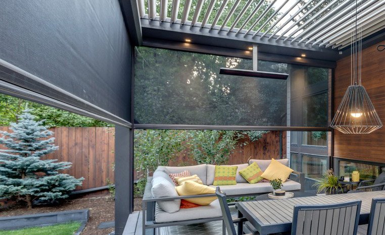 Covered outdoor living space with adjustable louvers and patio seating