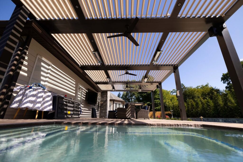 Louvered outdoor shade structure covering a backyard pool and patio